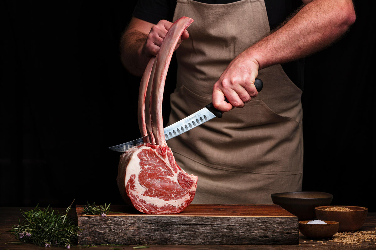 person-holds-a-sharp-knife-over-large-cut-of-meat