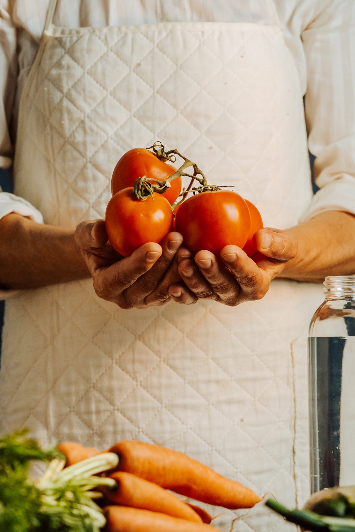 person-in-a-white-apron-cups-a-tomatoes